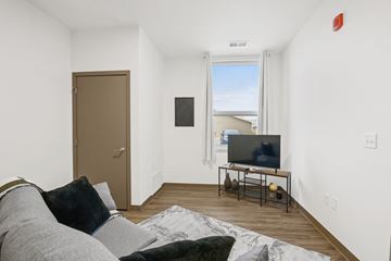 Neenah apartment for rent - A living room with a grey couch and a flat screen TV.