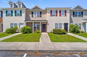 Jacksonville house for rent - A row of houses with green bushes in front.