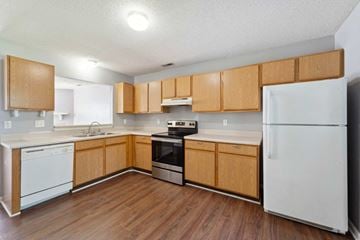 Jacksonville house for rent - A kitchen with wooden cabinets and white appliances.