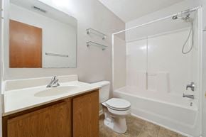 Jacksonville house for rent - A white bathroom with a toilet, sink, and bathtub.