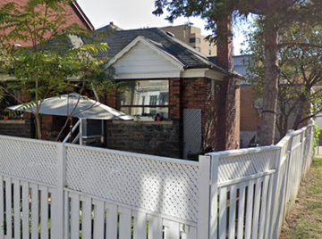 Toronto apartment for rent - A white picket fence in front of a house.