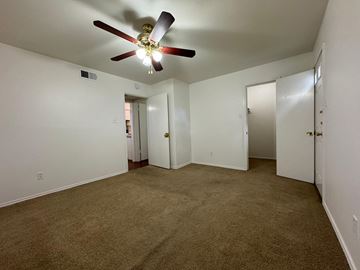 Austin apartment for rent - a living room with carpet and a ceiling fan