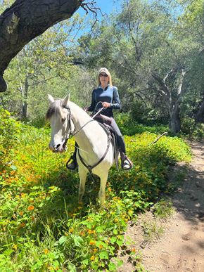 San Diego apartment for rent - A woman riding a white horse on a trail in the woods.