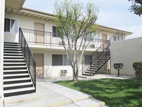 Upland apartment for rent - a building with stairs and a tree in front of it