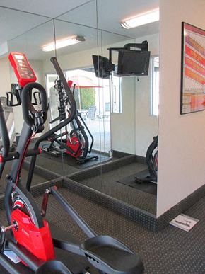 Arcadia apartment for rent - a gym with a red exercise bike and a mirror
