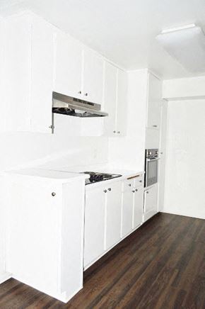 Los Angeles apartment for rent - an empty kitchen with white cabinets and a stove