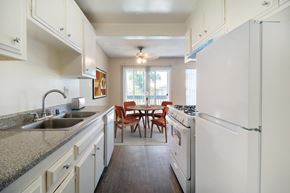 Upland apartment for rent - A kitchen with white appliances and a table with chairs.