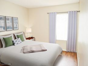Upland apartment for rent - a bedroom with a white bed and white and green pillows