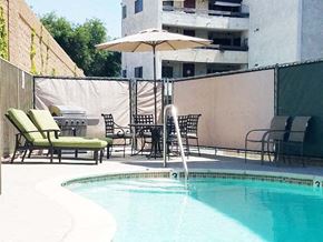 Burbank apartment for rent - a swimming pool with chairs and an umbrella