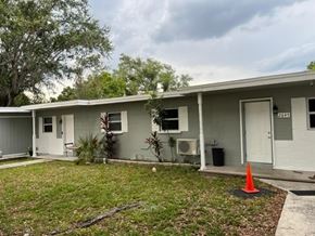 Fort Myers apartment for rent - A small white house with a grey roof and a sign that says "PEARL" on the door.