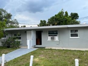 Fort Myers apartment for rent - A house with a grey exterior and a brown door.