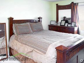 Kansas City apartment for rent - Large carpeted bedroom with four poster bedframe and mattress with grey bedding
