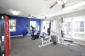 Kansas City apartment for rent - Workout room with modern gym equipment and bright blue wall