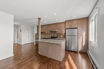 Calgary apartment for rent - A kitchen with wooden cabinets and a marble countertop.