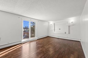Calgary apartment for rent - A room with wooden floors and white walls.