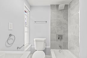 Philadelphia apartment for rent - A white toilet sits in a bathroom next to a bathtub.
