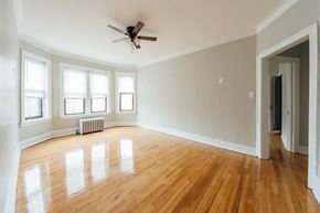 Chicago apartment for rent - an empty living room with wood floors and a ceiling fan