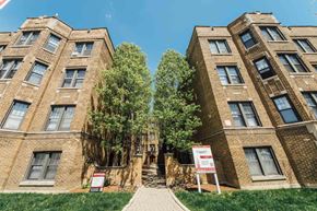 Chicago apartment for rent - two large brick buildings with trees between them and a sidewalk