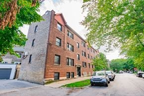 Chicago apartment for rent - a brick building with cars parked in front of it on a street