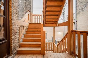 Chicago apartment for rent - a staircase with wooden stairs next to a brick building