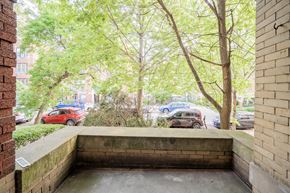 Chicago apartment for rent - the entrance of a building with trees and cars on the street