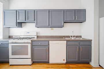 Chicago apartment for rent - a kitchen with blue cabinets and white appliances