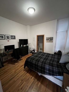 Chicago apartment for rent - a bedroom with a bed and a wooden floor