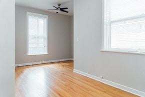 Chicago apartment for rent - an empty room with a ceiling fan and two windows