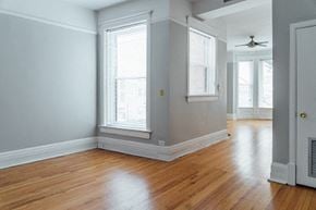 Chicago apartment for rent - an empty living room with wood floors and windows