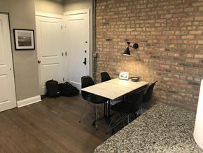 Chicago apartment for rent - a dining room with a table and chairs and a brick wall