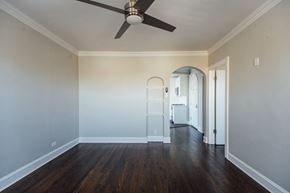 Chicago apartment for rent - a living room with white walls and a ceiling fan
