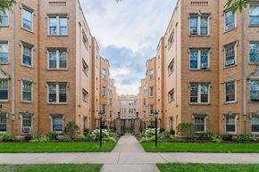 Chicago apartment for rent - a pathway between two brick apartment buildings with grass