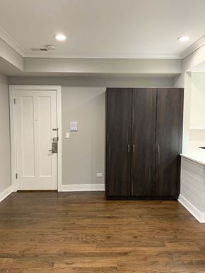 Chicago apartment for rent - a living room with a wooden floor and a large wooden closet