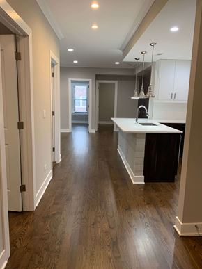 Chicago apartment for rent - a renovated kitchen and living room with hardwood floors and white cabinets