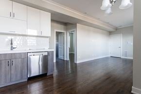 Chicago apartment for rent - an empty kitchen and living room with white cabinets