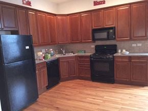Chicago apartment for rent - a kitchen with black appliances and wooden floors