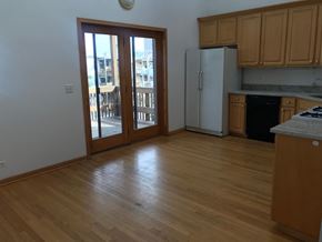 Chicago apartment for rent - an empty living room with wood floors and a door to a balcony