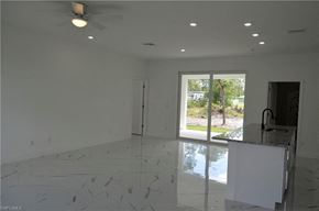 Lehigh Acres house for rent - an empty living room with a marble floor and a sliding glass door