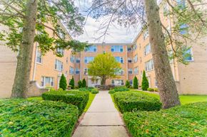 Skokie apartment for rent - an exterior view of a building with a sidewalk and trees