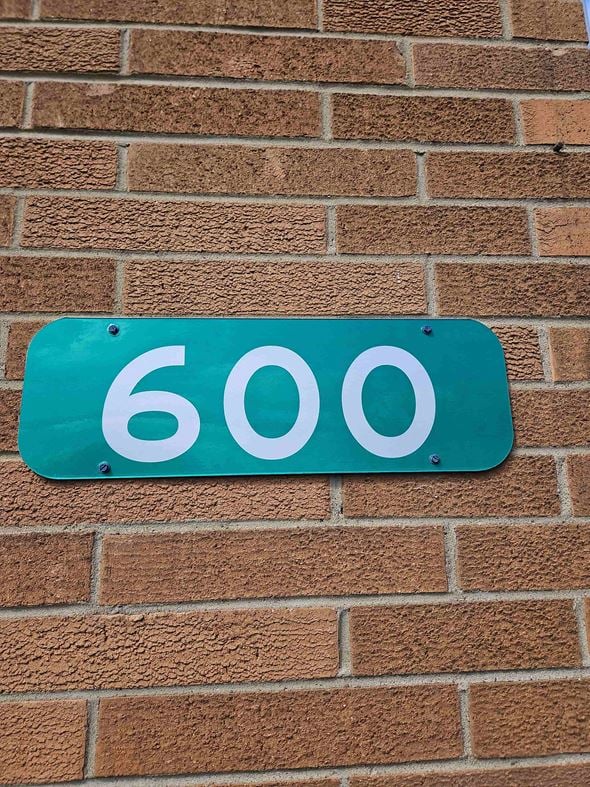 Niles apartment for rent - a blue sign with the number 60 on a brick wall