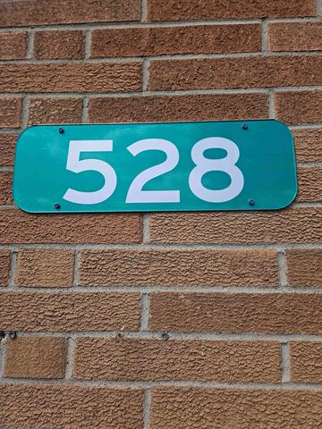 Niles apartment for rent - a blue sign with the number 5228 on a brick wall