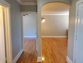 Chicago apartment for rent - a living room and dining room with a hard wood floor and an arched doorway