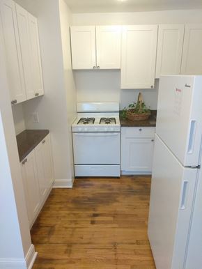 Chicago apartment for rent - a kitchen with white cabinets and a white stove and refrigerator