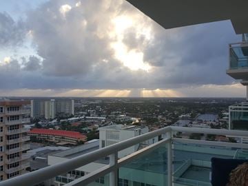 Fort Lauderdale apartment for rent - A cityscape viewed from a balcony with a mix of modern and older buildings.