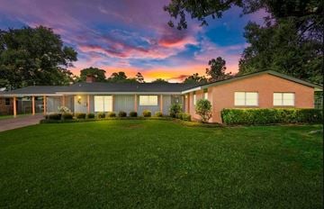 Beaumont house for rent - a house with a lawn in front of a sunset