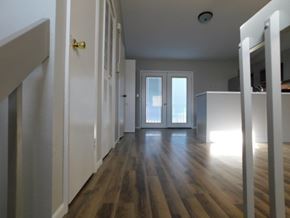 Fountain house for rent - A long hallway with white walls and wood flooring.