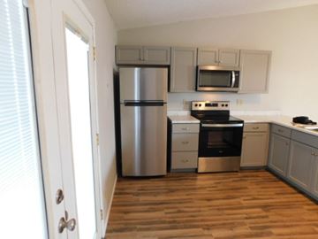 Fountain house for rent - A kitchen with a stainless steel refrigerator, microwave, and oven.