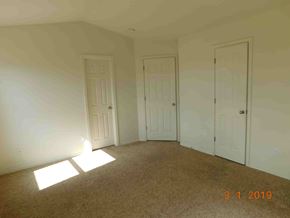 Fountain house for rent - A room with carpeted floor and four doors.