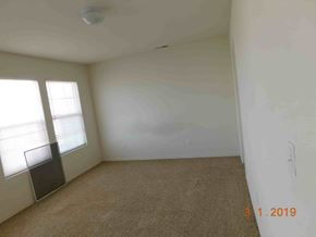 Fountain house for rent - A room with a carpet floor, a window with blinds, and a wall with a date stamp.
