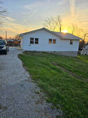 Ashland house for rent - a house with a gravel driveway and a sunset in the background